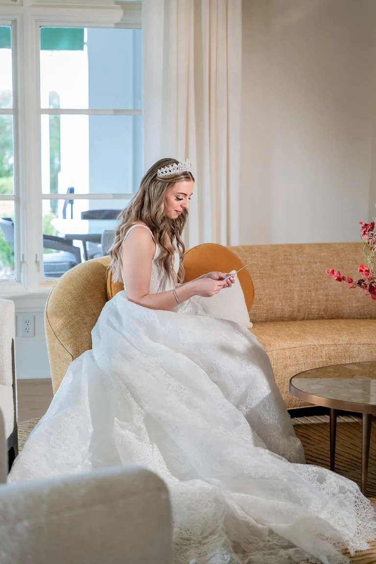 Bride in a white gown getting ready reading her husband's love letter to her