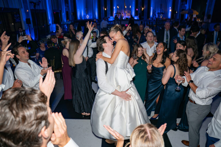 groom lifting his bride into the air during their wedding reception