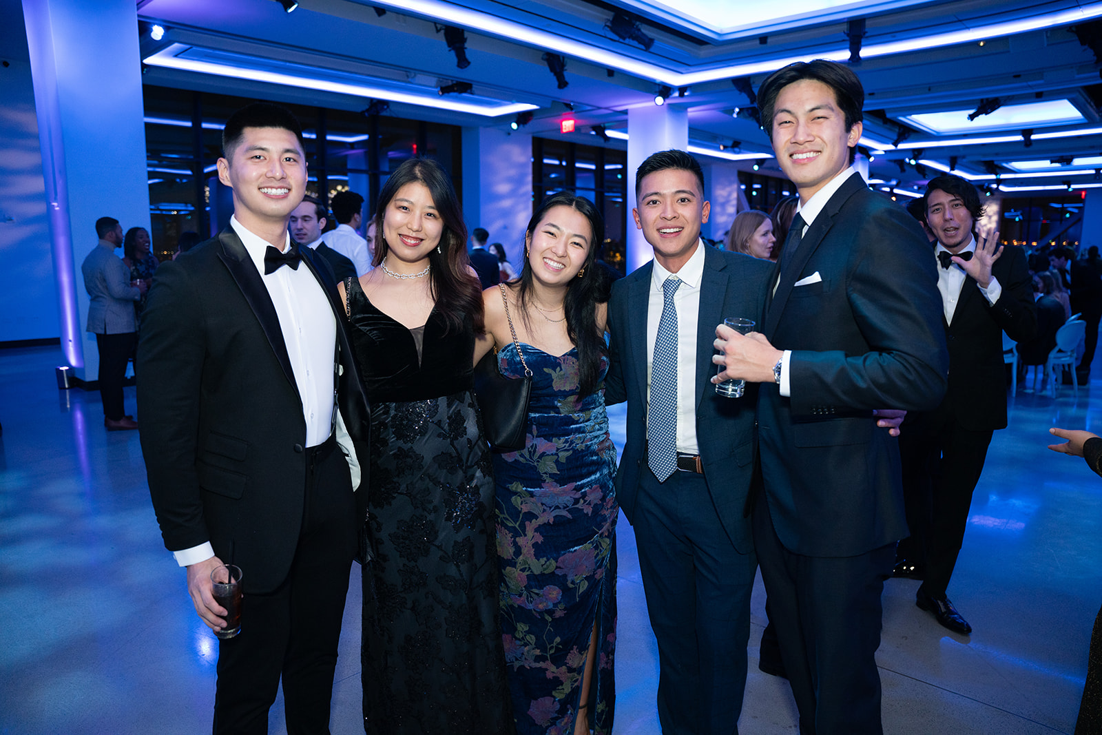 Group of students dressed formally smiling at the camera at Columbia Business School event at The Glasshouses in NYC