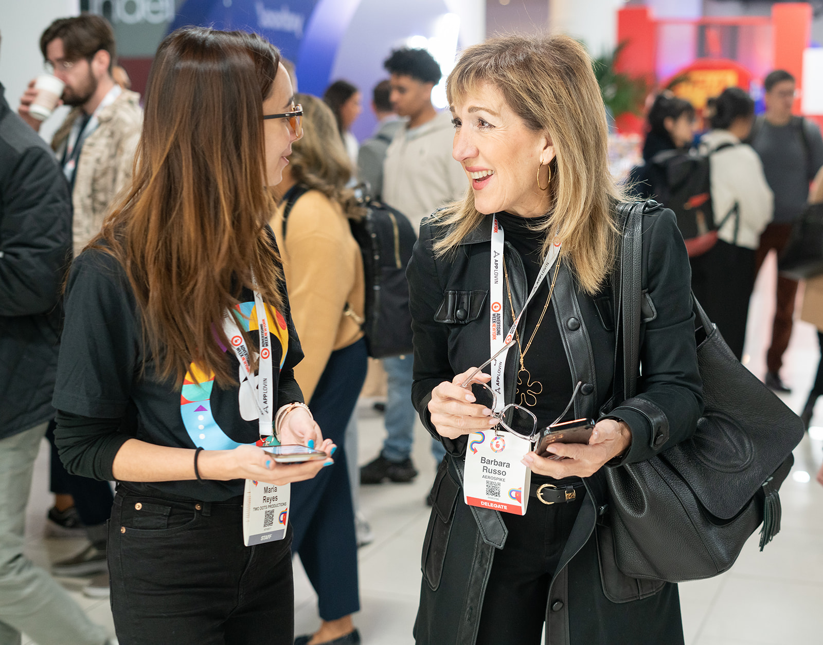 Two women smiling and having a joyful conversation while at New York Advertising week